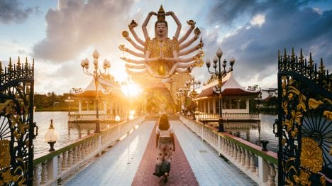 my-thailand-woman-walking-towards-the-big-buddha-temple-at-sunset