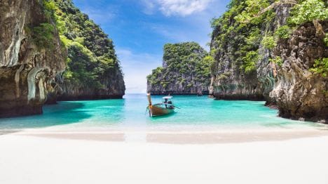my-thailand-boat-in-turquoise-water-arriving-in-a-rocky-bay-and-white-sands-in-phuket
